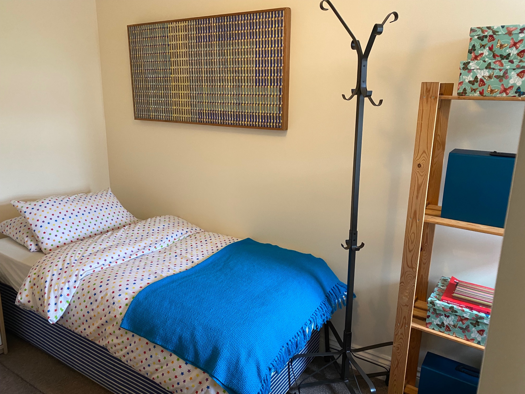 Bedroom with single bed and blue throw